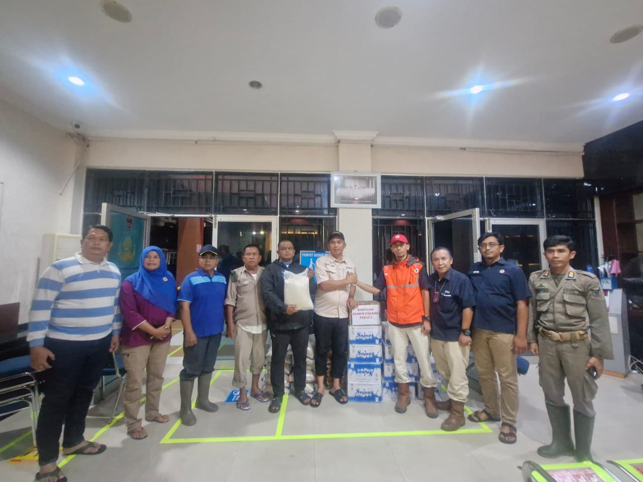 Penyerahan bantuan bencana dari Kepala Unit Komunikasi & Kesekretariatan PT Semen Padang Ilham Akbar kepada Camat Lubuk Begalung Nofiandi Amir, Kamis malam (28/11/2025)